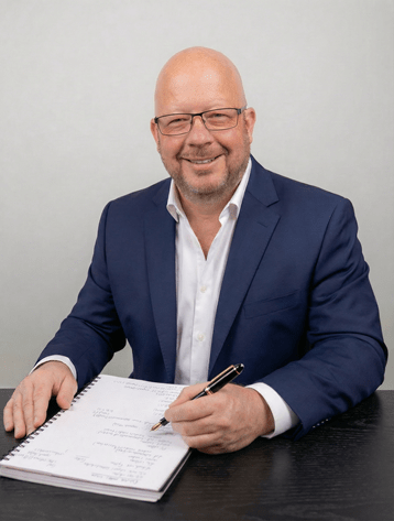 Dr Jed Jones, founder of JLytics, writing at his desk