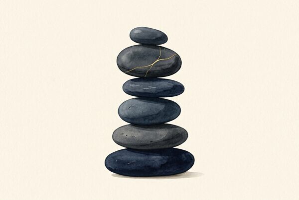 Balanced stack of slate and navy stones with one stone showing a fine gold hairline crack